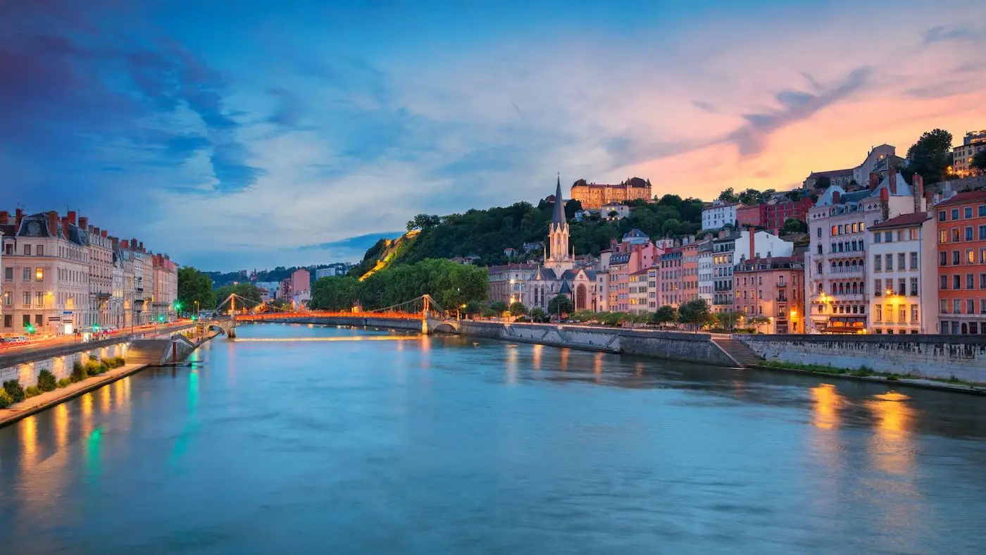 Onde ficar em Lyon: melhores opções de hospedagem. Iamgem: foto do rio em Lyon ao por do sol, com as casas histórias em ambas as margens.