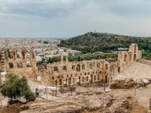 Onde ficar em Atenas: imagem da Acrópolis, pegando um teatro grego e a cidade embaixo