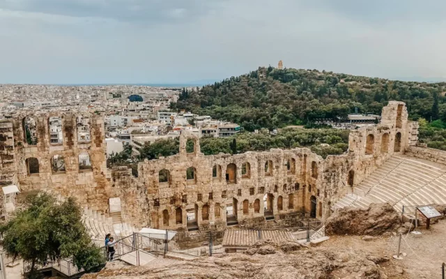 Onde ficar em Atenas: imagem da Acrópolis, pegando um teatro grego e a cidade embaixo