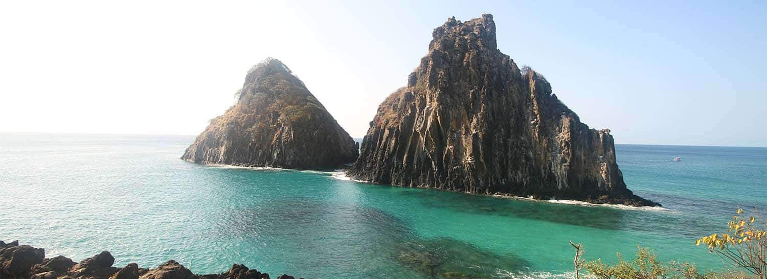 mar verde de fernando de noronha com morros dois irmãos