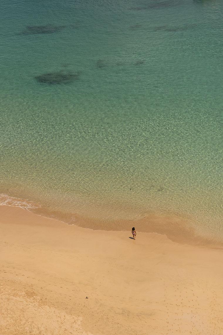 Praia do Sancho vista de cima, com uma única pessoa na areia e água azul clara