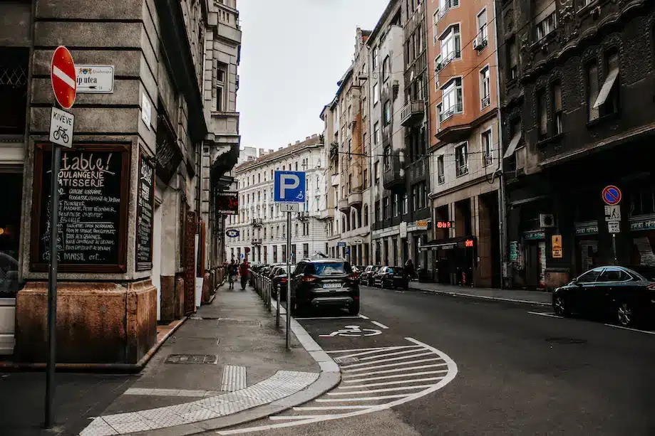 Rua no distrito judeu de Budapeste, cheia de prédios de coloração escura e com aparência de antigos