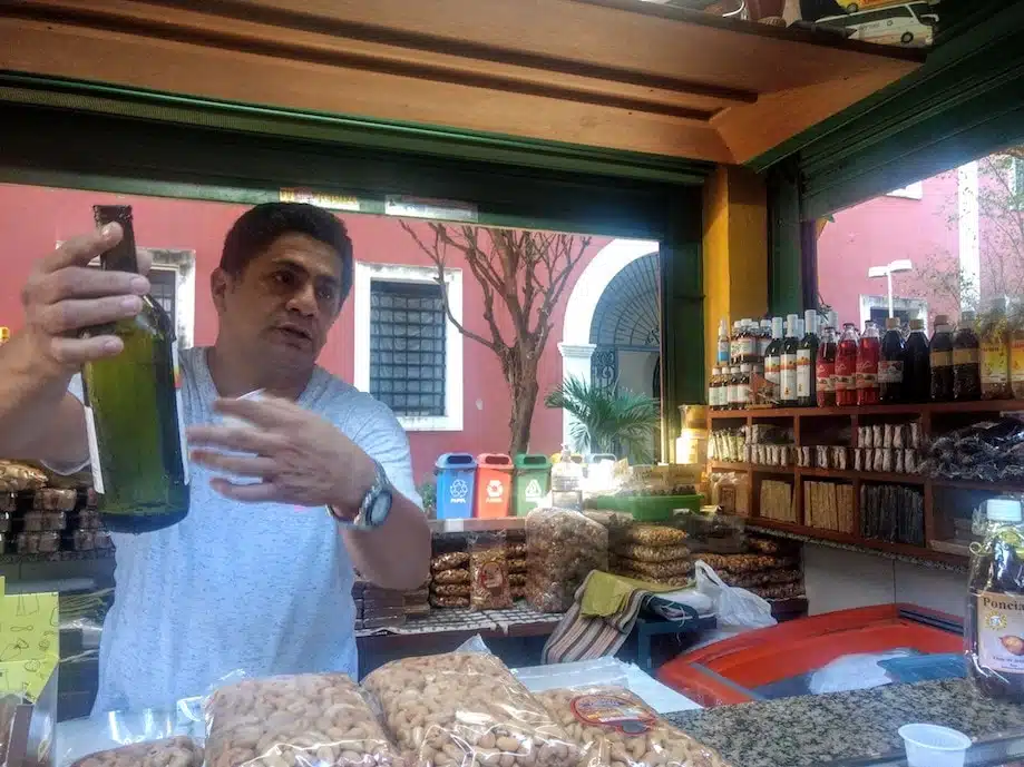 Comidas Típicas do Ceará: Vendedor oferece vinho de Caju em feira de fortaleza
