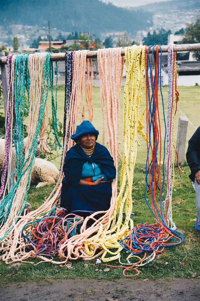 Imagem de uma senhora usando vestimenta azul no Mercado de animais de Otavalo, Equador