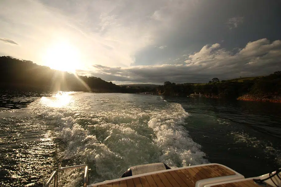 barco navega pelo Lago de Furnas ao pôr do sol