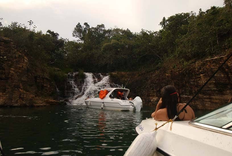 mulher observa cachoeira a partir de barco