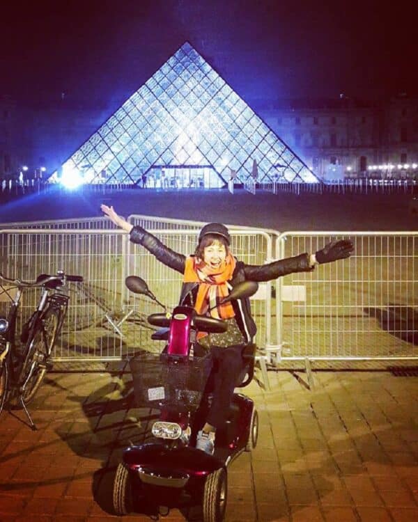 cadeirante em frente ao museu de louvre à noite