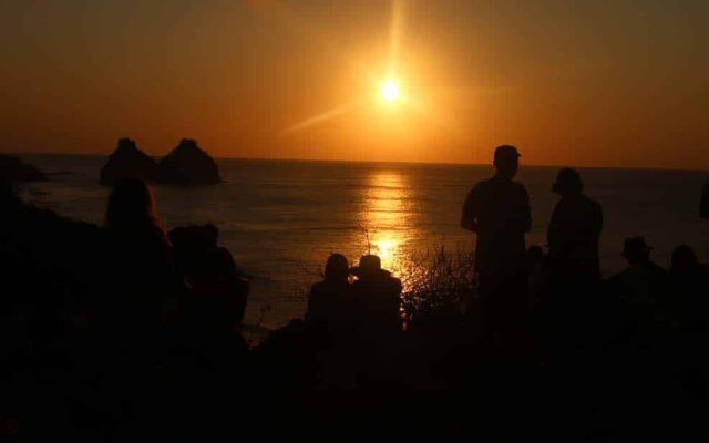 pessoas assistem ao pôr do sol no forte do boldró