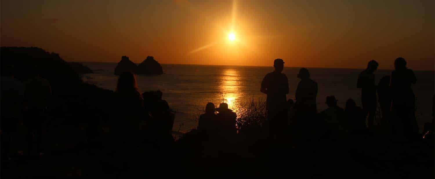 pessoas assistem ao pôr do sol no forte do boldró