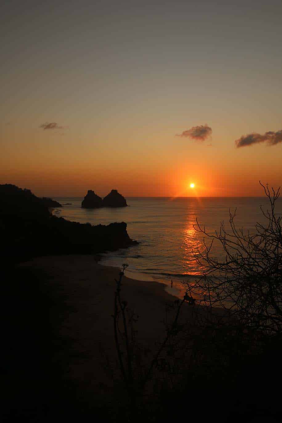 vista do forte do boldró na hora do pôr do sol, com mar, praia e morro dois irmãos, em Fernando de Noronha