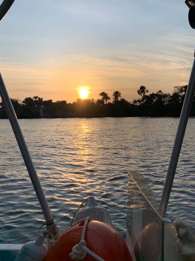 por do sol no rio preguiças em barreirinhas com árvores e barco