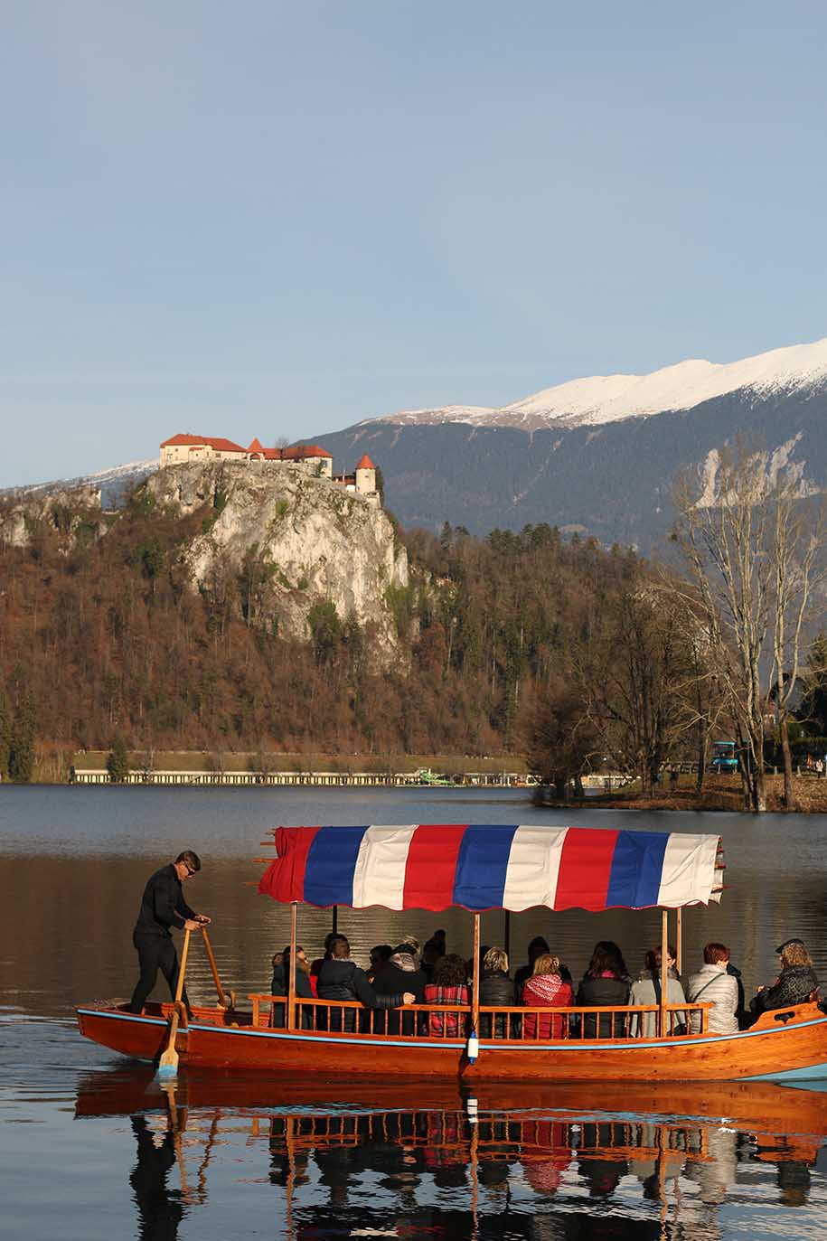 barco em lago bled, com castelo e montanha nevada ao fundo