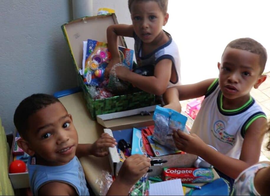 crianças abrindo presentes natal caixa de sapatos