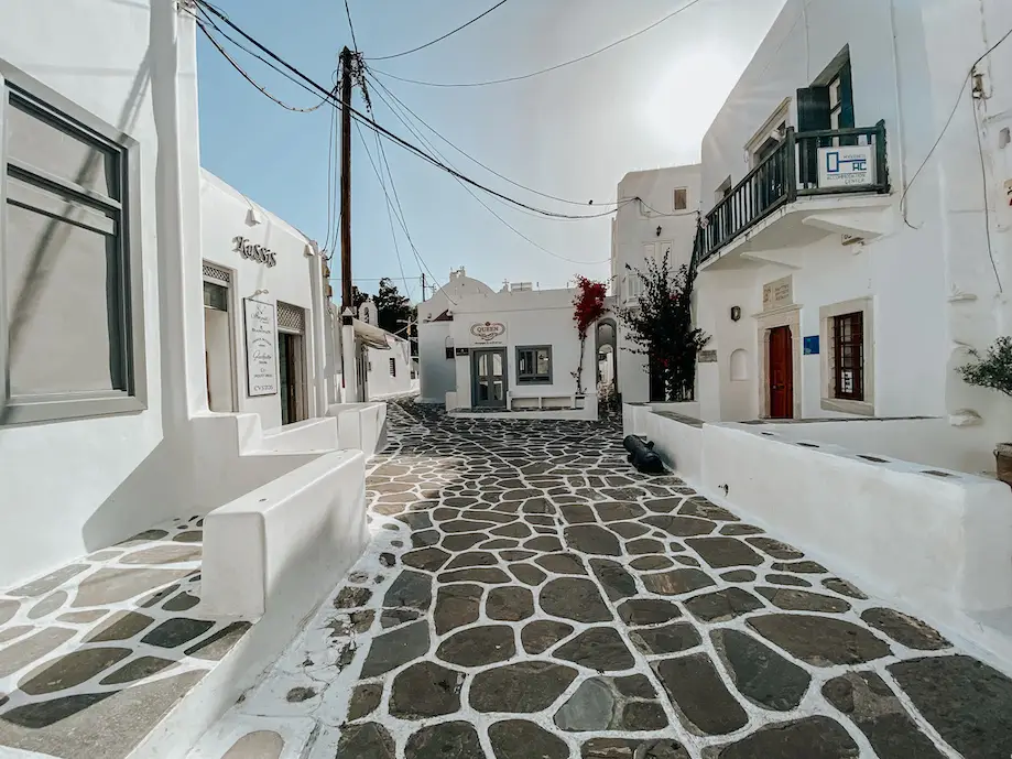 Rua de Chora, centro de Mykonos, com casinhas brancas de janelas e portas coloridas e o chão de pedras