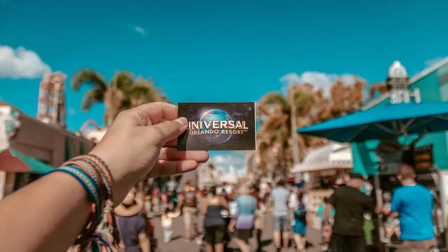 Onde ficar em Orlando, perto dos parques da Universal Studios? Foto de uma pessoa segurando um bilhete de entrada escrito Universal em frente a um dos parques