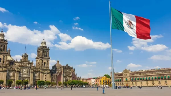 Praça central do Zócalo com catedral ao fundo e uma bandeira Mexicana. O centro histórico concentra a maior parte das opções de hospedagem na cidade do México.
