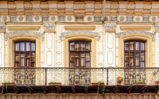 Onde ficar em Cuenca, Imagem de janelas coloniais em casarão do centro histórico