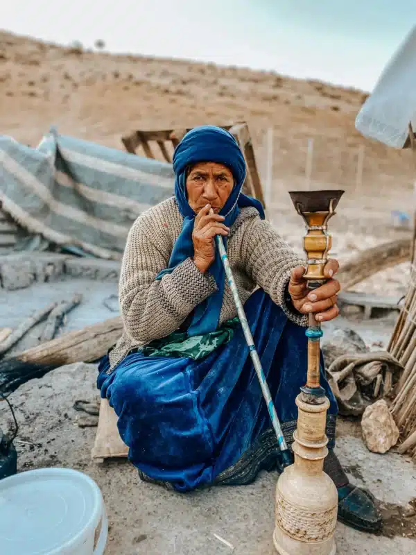 Mulher Qashqai fumando shisa na cordilheira de Zagros, no Irã 