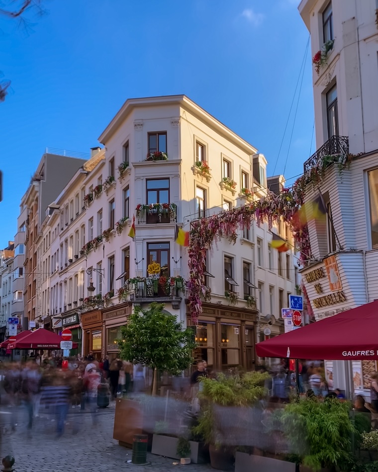rua em bruxelas com cafes e lojas de waffles e batata frita